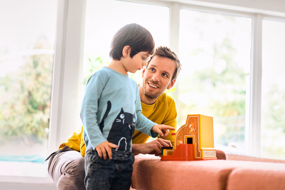 Vater mit seinem Sohn vor einer Couch
