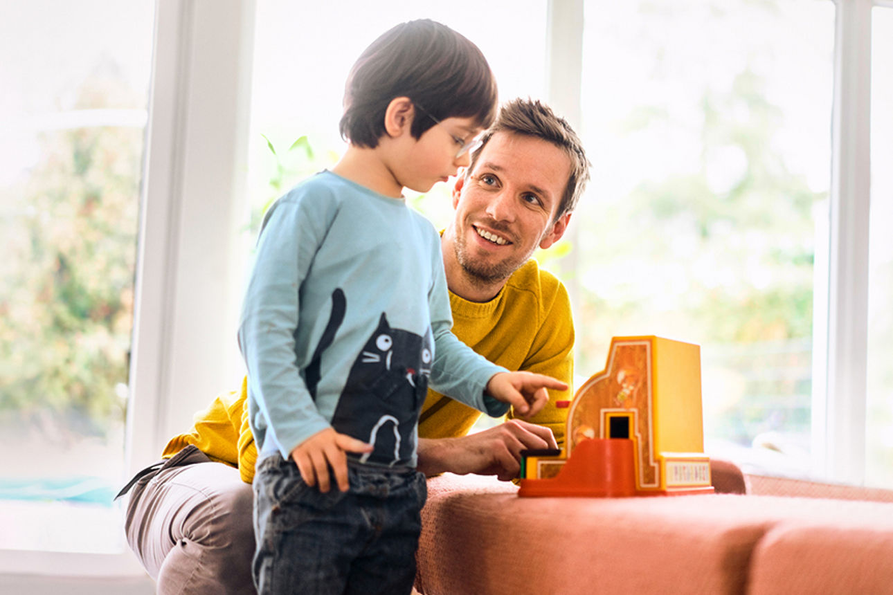 Vater mit seinem Sohn vor einer Couch