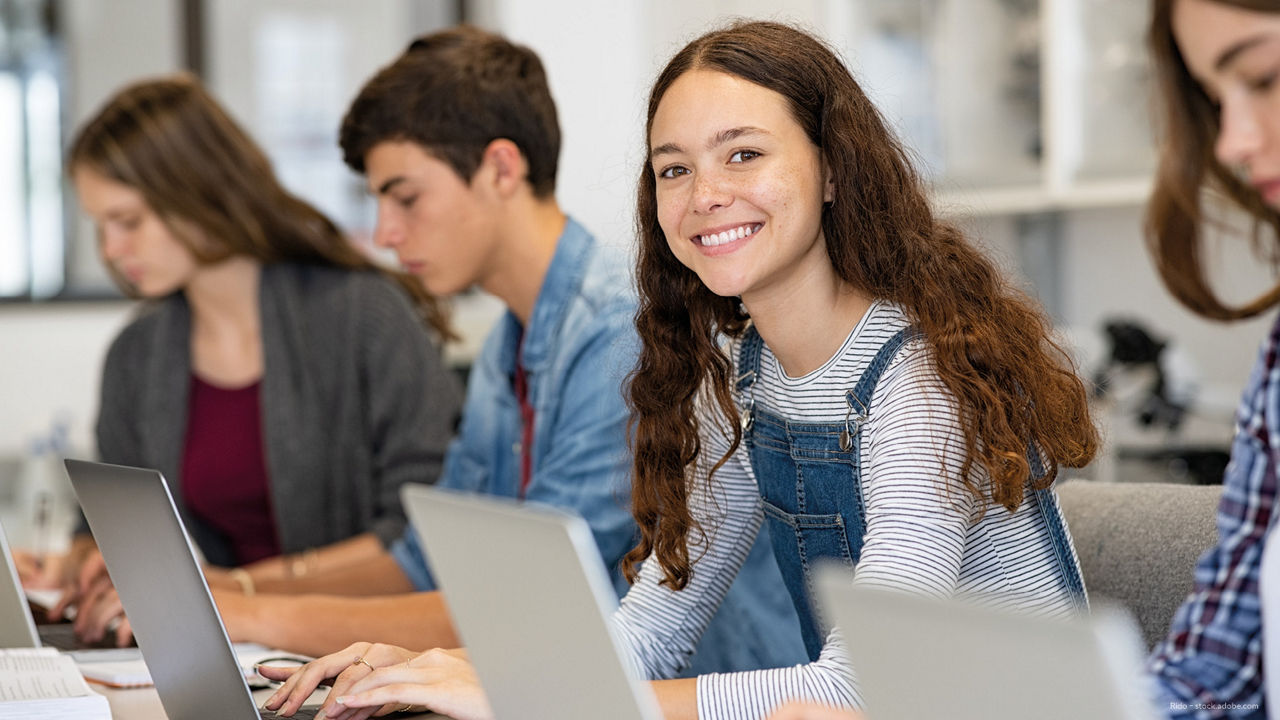 mehrere Kinder sitzen am Tisch vor den Computern