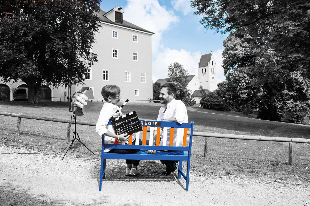 Frau und Mann sitzen auf einer Bank im Garten