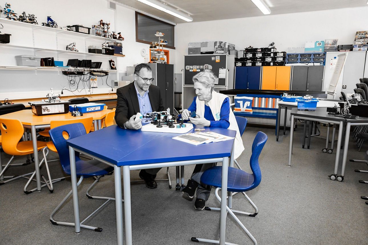 Bankvorstand Ulrich Zeiler und Eva Rehm vom MINT-Campus sitzen an einem Tisch.