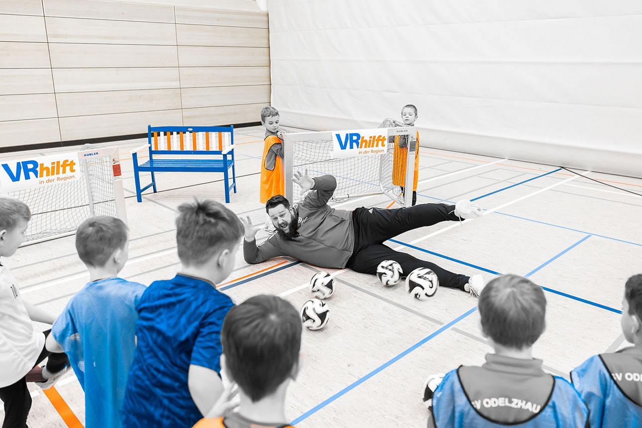 Fussballkinder und ihr Trainer beim Hallenfußball