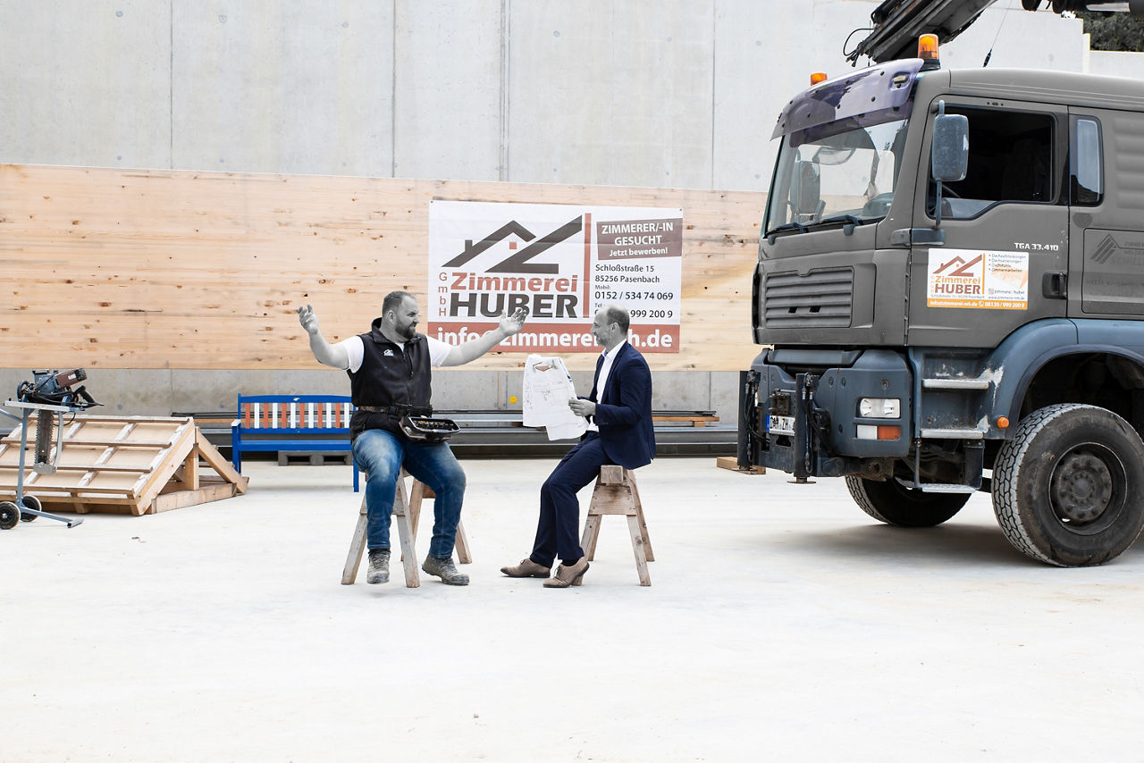 Zwei Männer unterhalten sich neben einem LKW