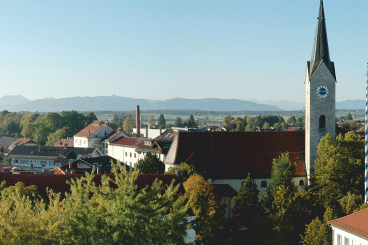 Ansicht auf Holzkirchen mit Blick in die Berge
