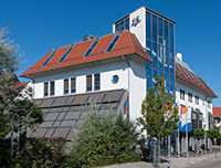  Ein weißes Gebäude mit rotem Dach und roten Fenstern