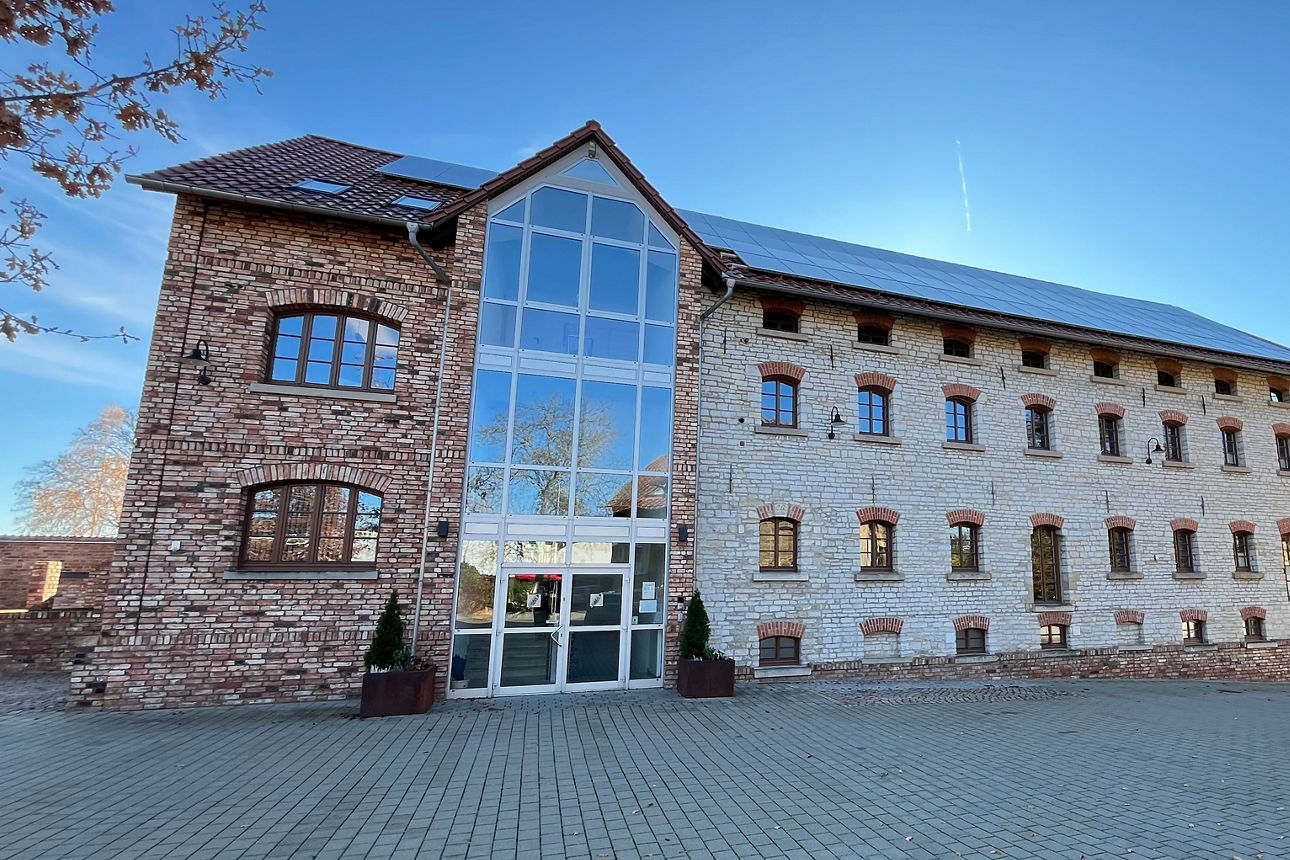Großes weißes Backsteinhaus mit Solarpanelen auf Dach