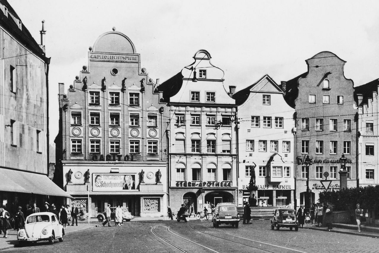 Ein schwarz-weiß Bild von Augsburg mit verschiedenen Gebäuden in einer Reihe.