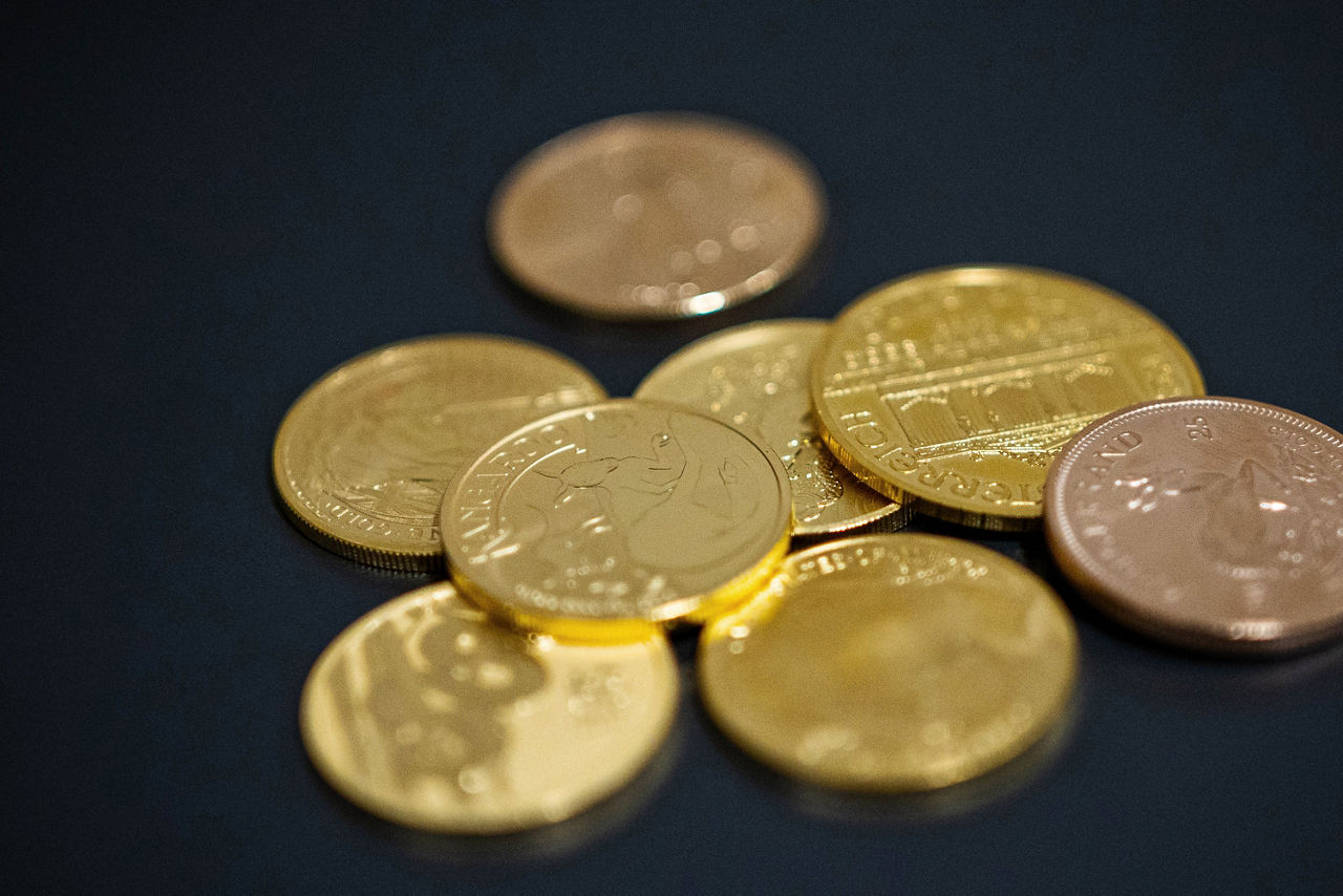 Goldmünzen liegen auf einem schwarzen Hintergrund
