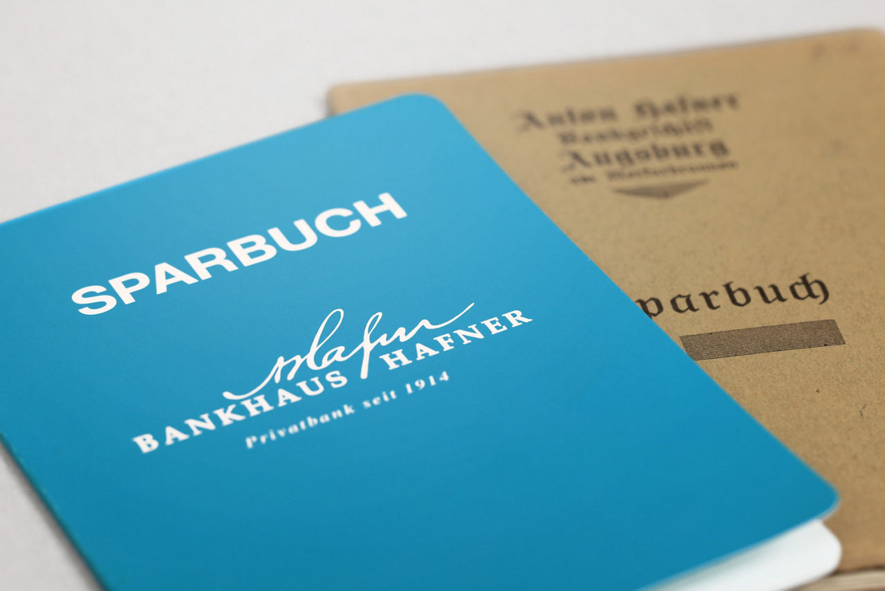 Dratsellung eines Sparbuchs mit der Aufschrift "Bankhaus Anton Hafner" in blau.