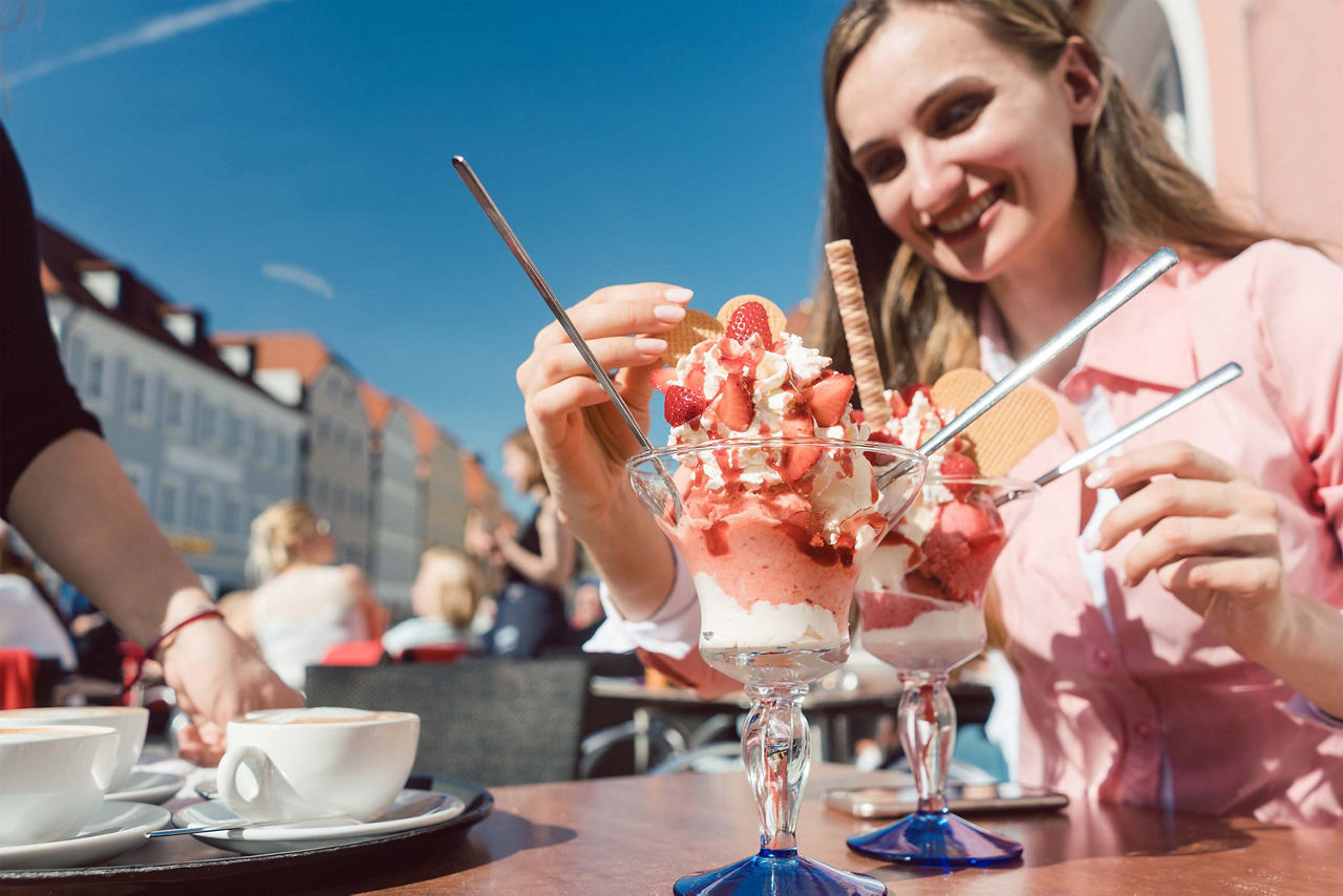 Frau in einem Café, isst ein Eis