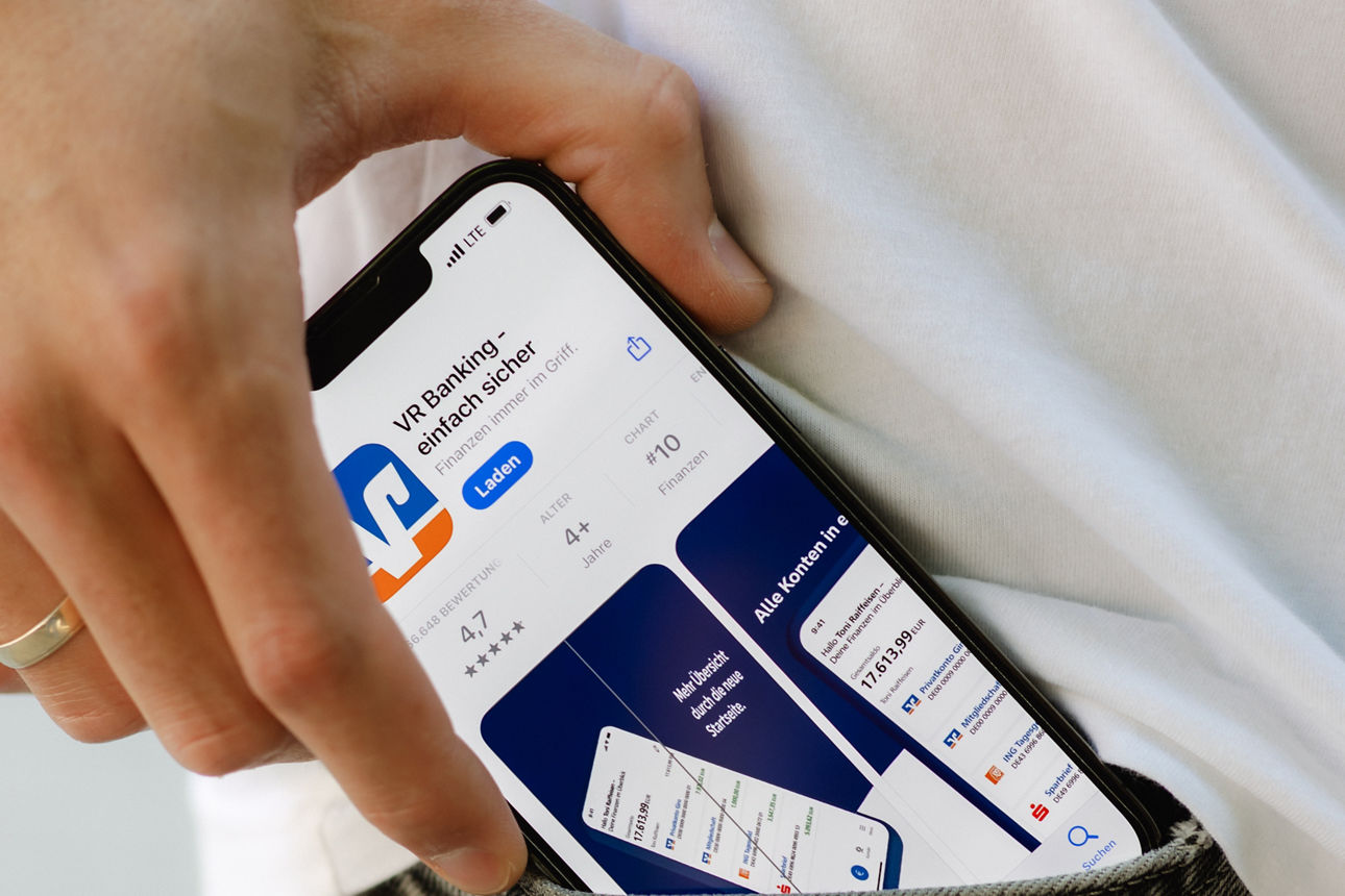 Ein Mann steht in der Stadt mit seinem Smartphone und nutzt die VR Banking App Ein Mann steht in der Stadt mit seinem Smartphone und nutzt die VR Banking App