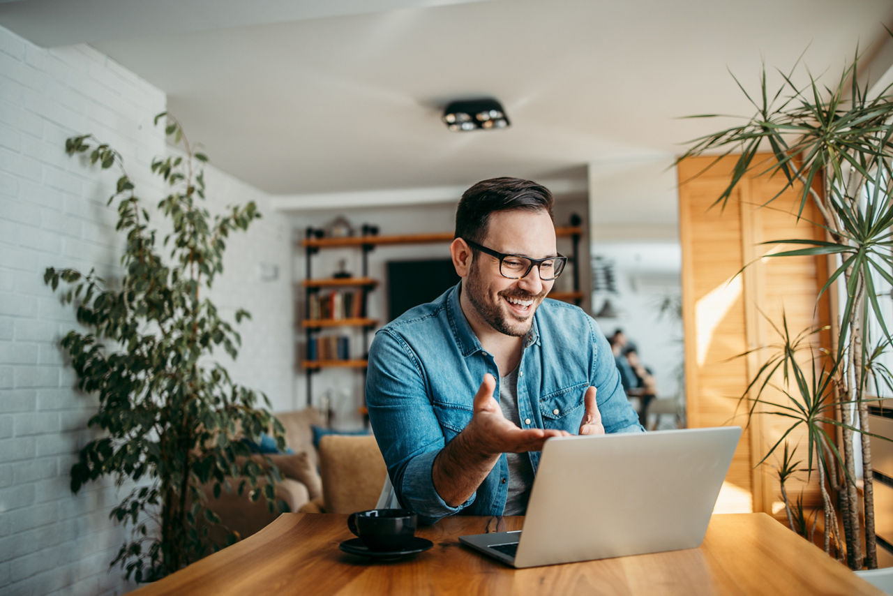 Lachender Mann mit Laptop