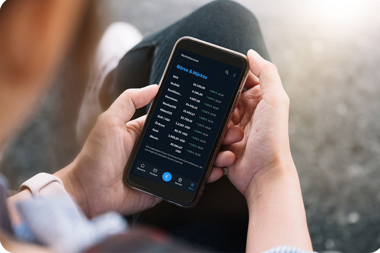Ein Mann hält sein Handy mit der Banking App in der Hand und schaut sein Depot an.