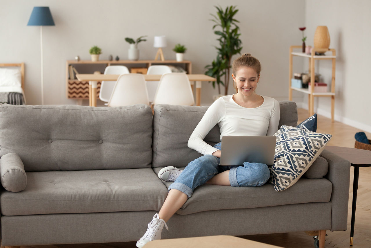 Junge Frau mit einem Laptop auf der Couch