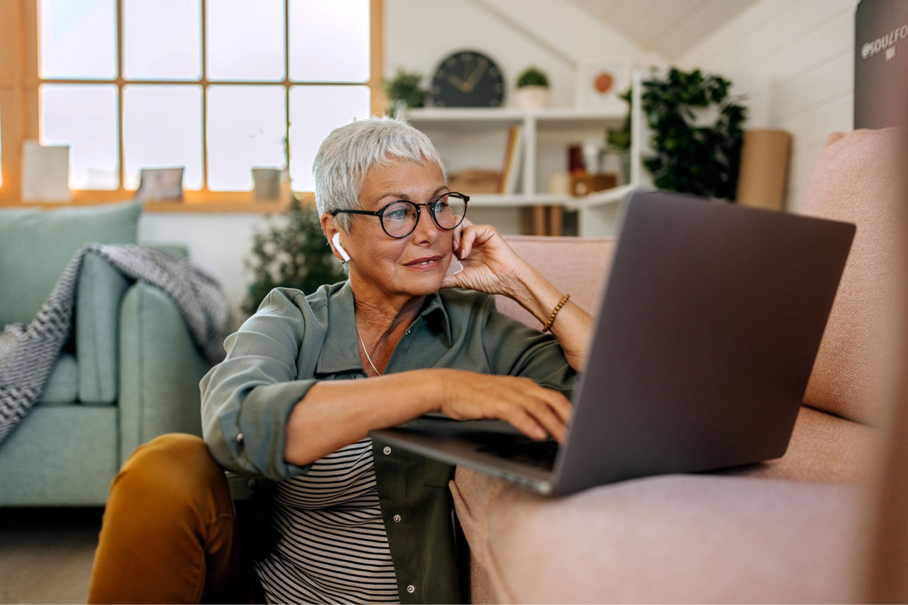 Seniorin benutzt einen Laptop im Wohnzimmer