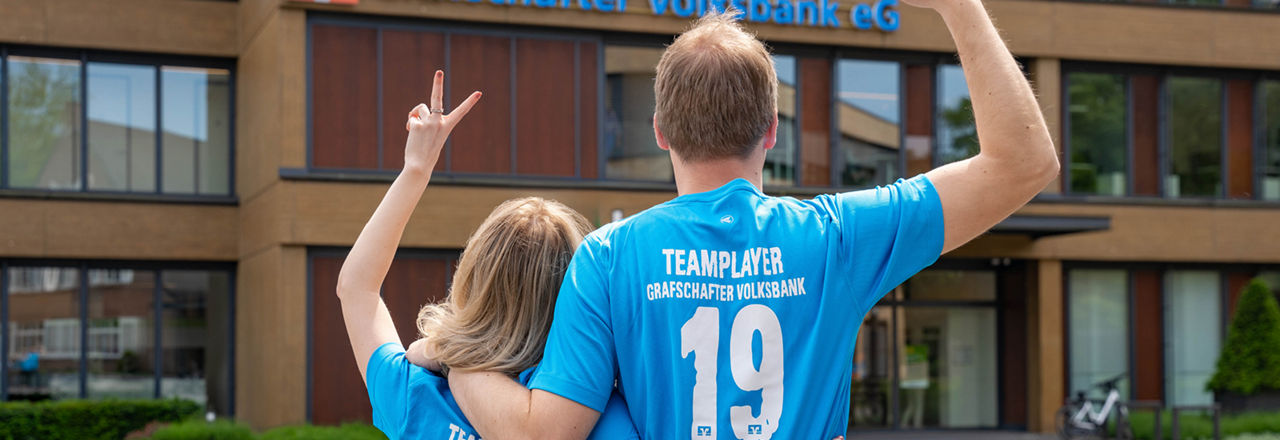 Trikotaktion: Zwei Personen im Trikot von hinten die jubeln