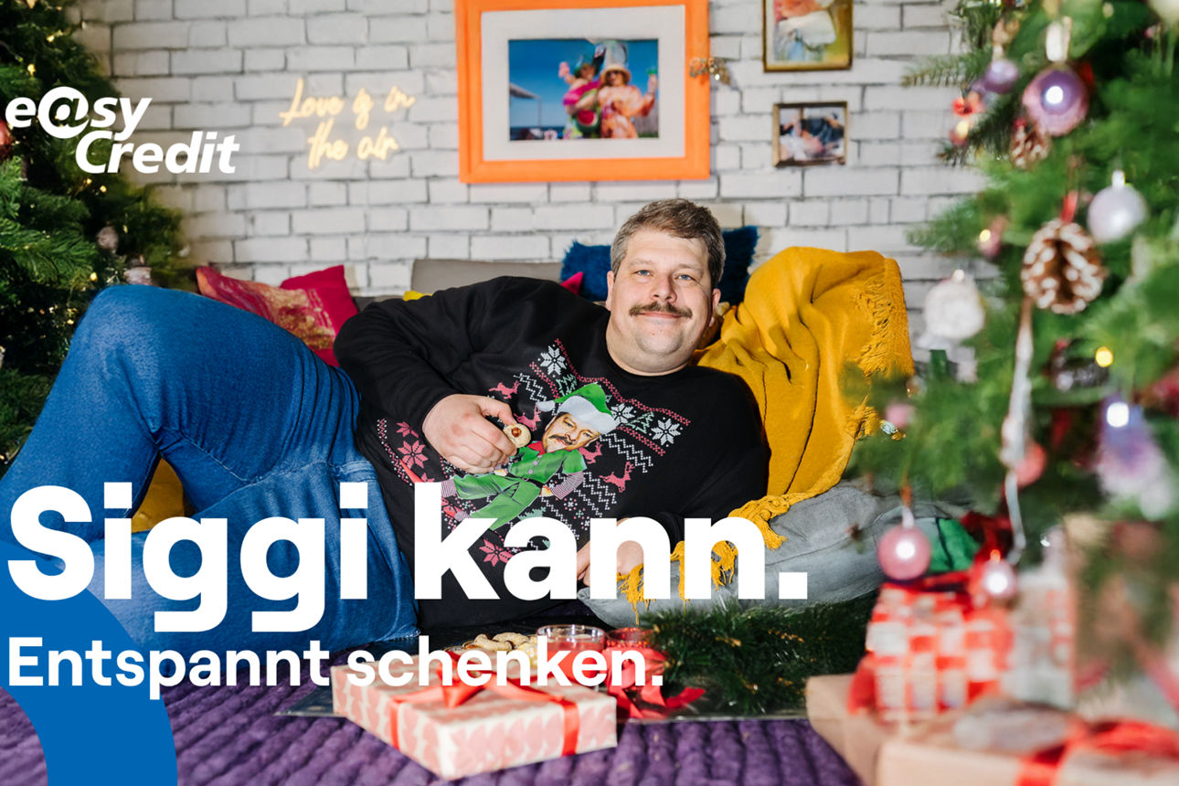 Ein Mann in Weihnachtspullover liegt auf dem Sofa