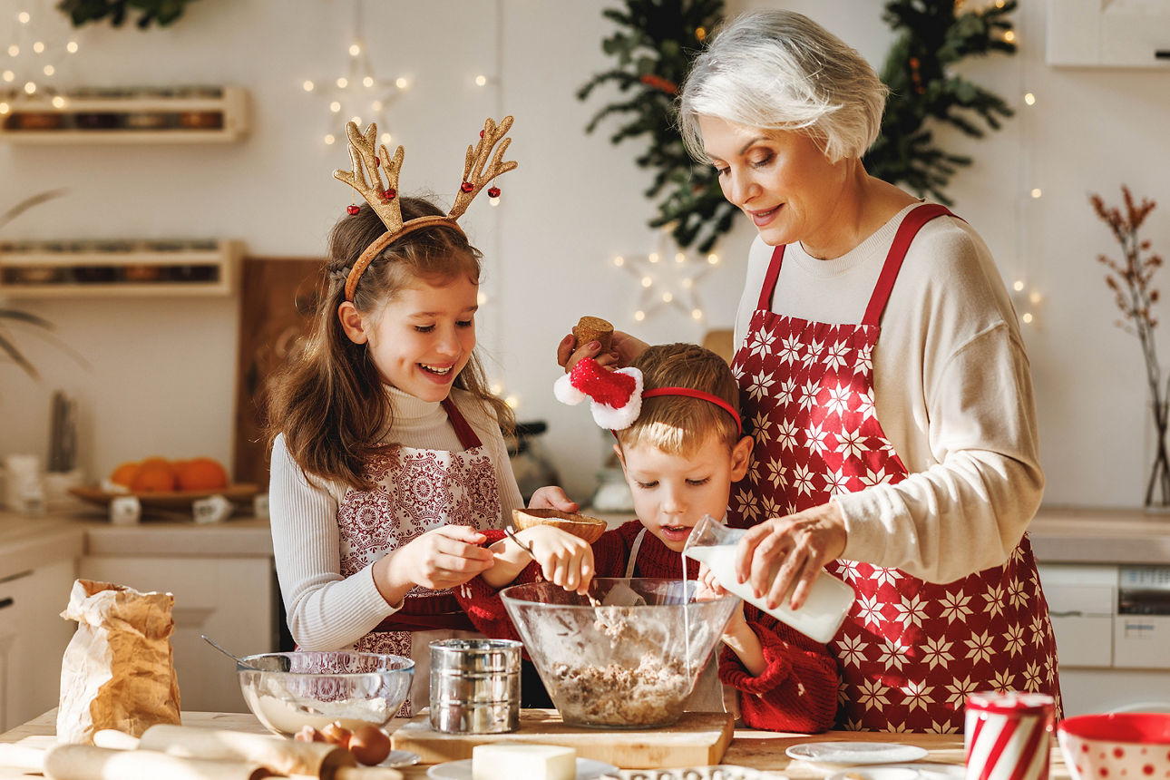 Eine Alte Frau und Ihre Enkelkinder sind am Backen