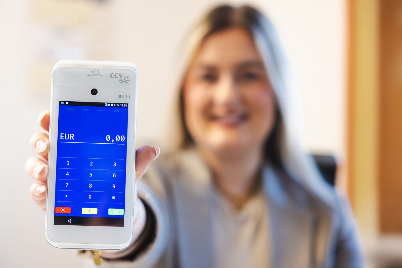 Frau hält Smartphone in die Kamera