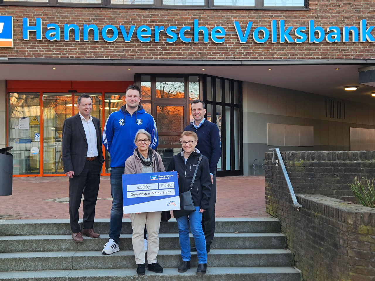 Fünf Personen halten ein Schild, auf dem 3.500 EURO Gewinnspar-Reinerträge steht