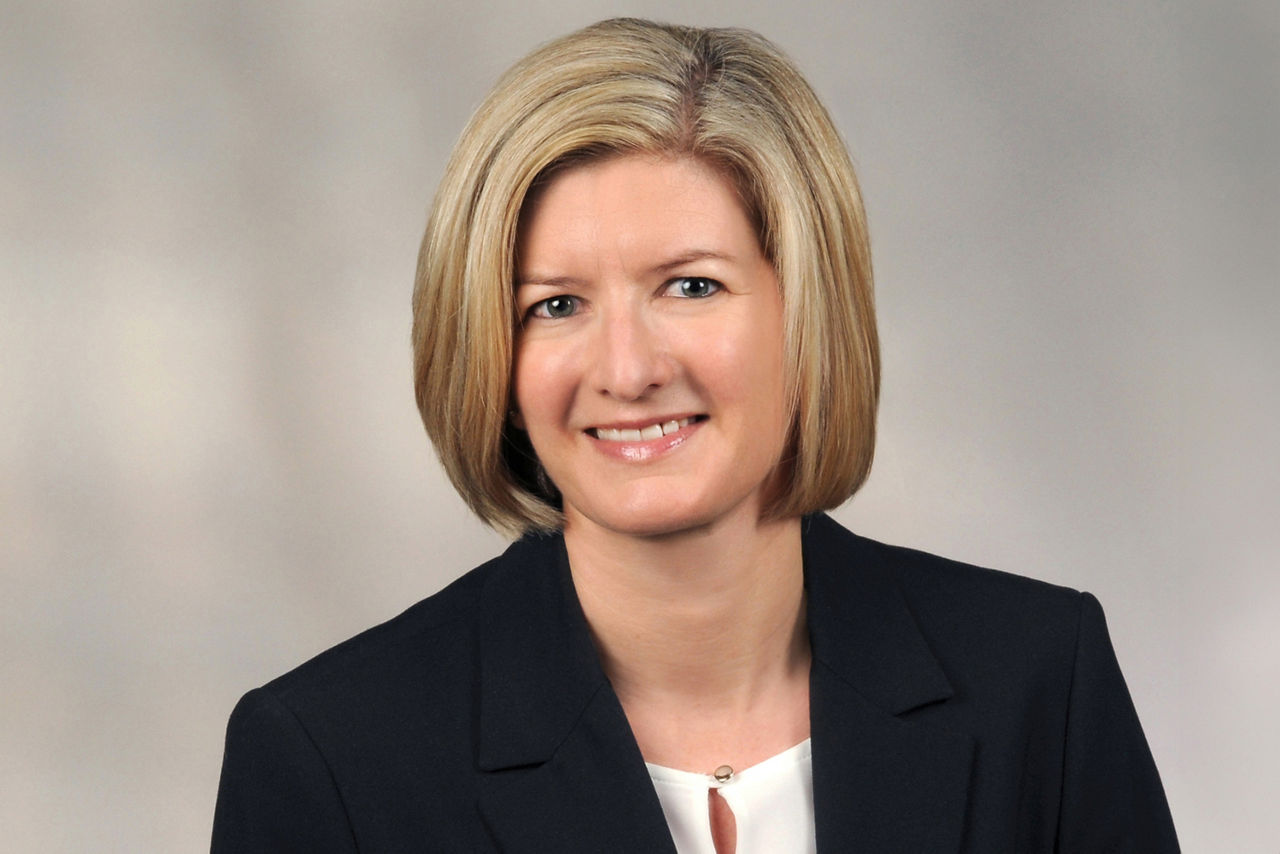 Jeanette Barth hat kurze blonde Haare und trägt ein Businessoutfit