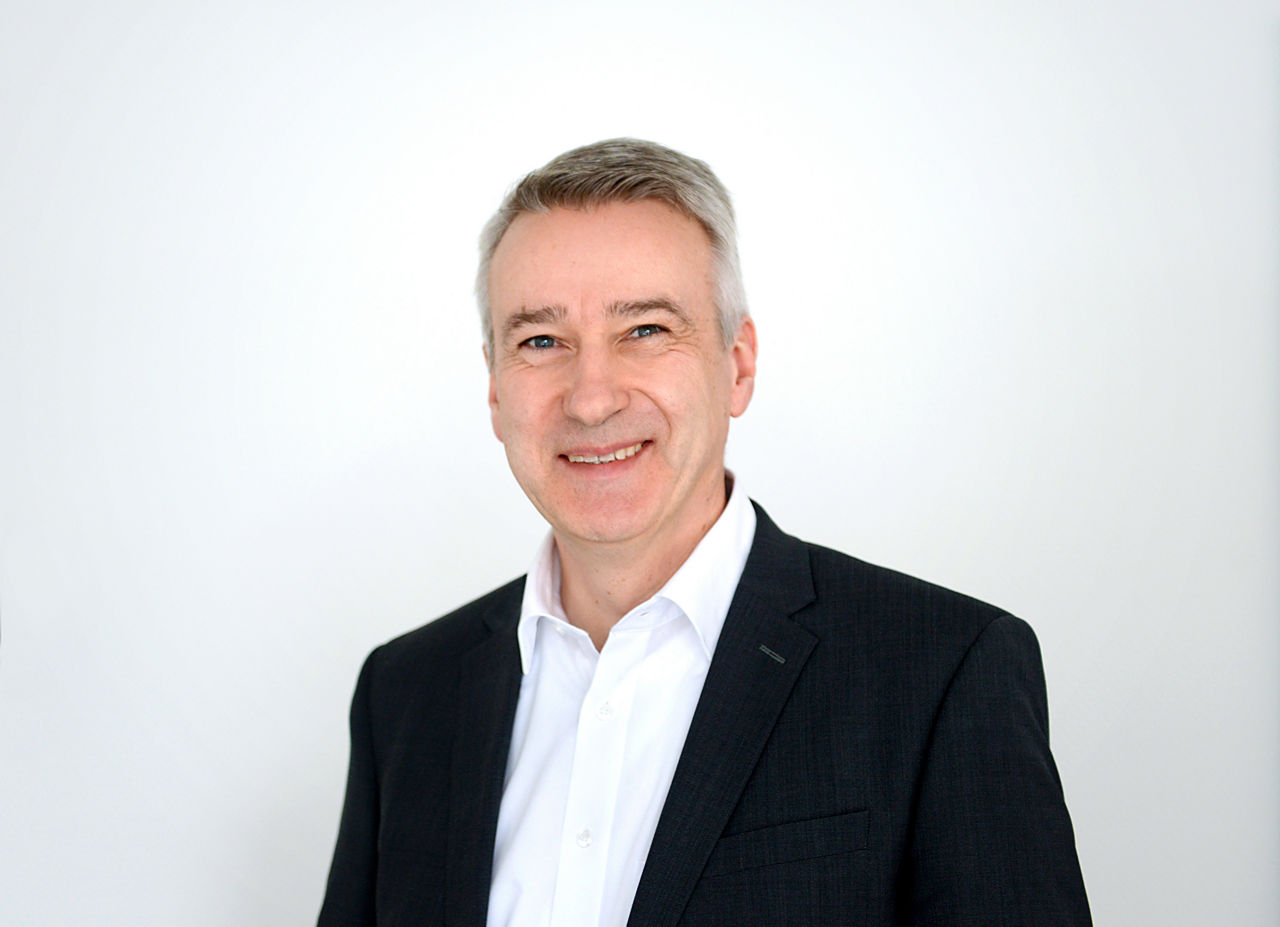 Firmenkundenberater Stephan Bartsch vor grauen Hintergrund