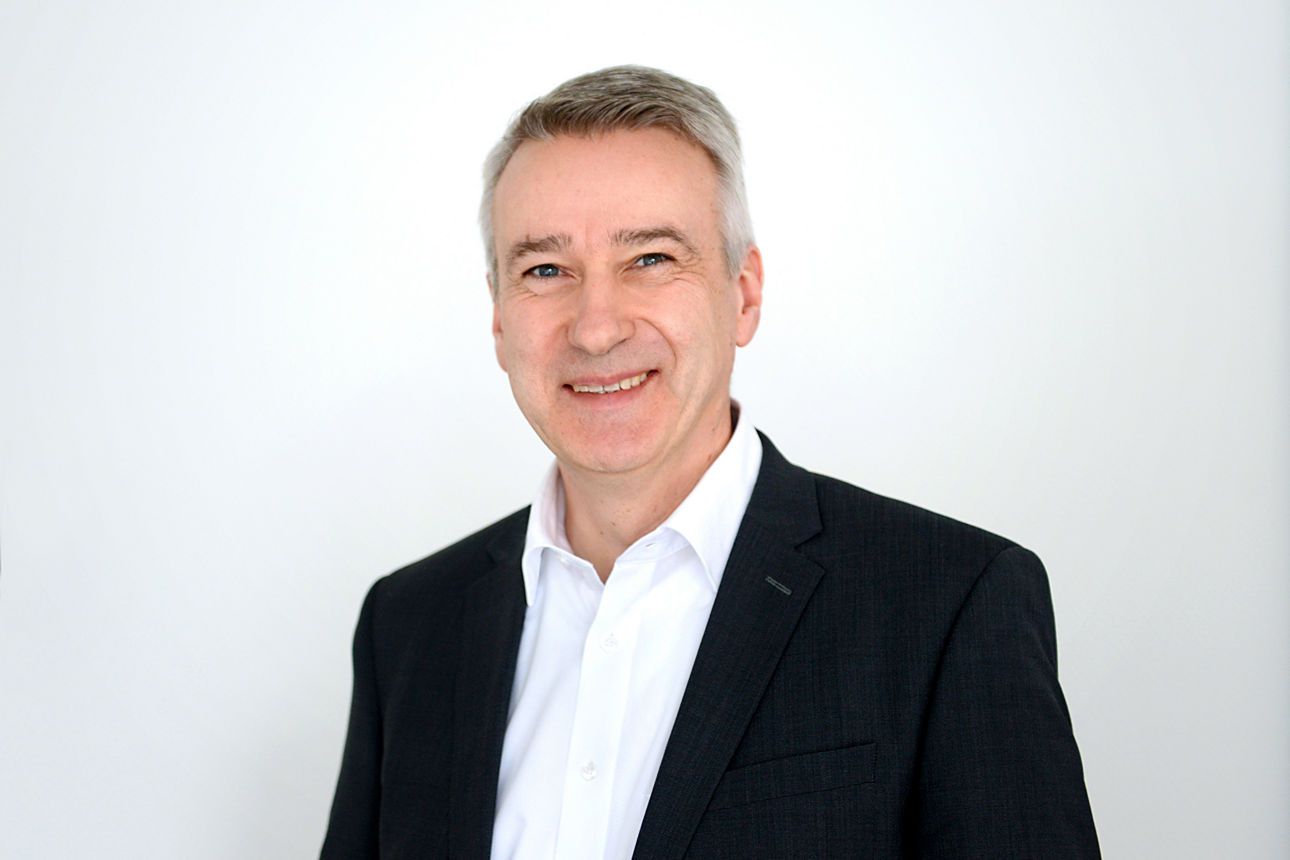 Firmenkundenberater Stephan Bartsch vor grauen Hintergrund