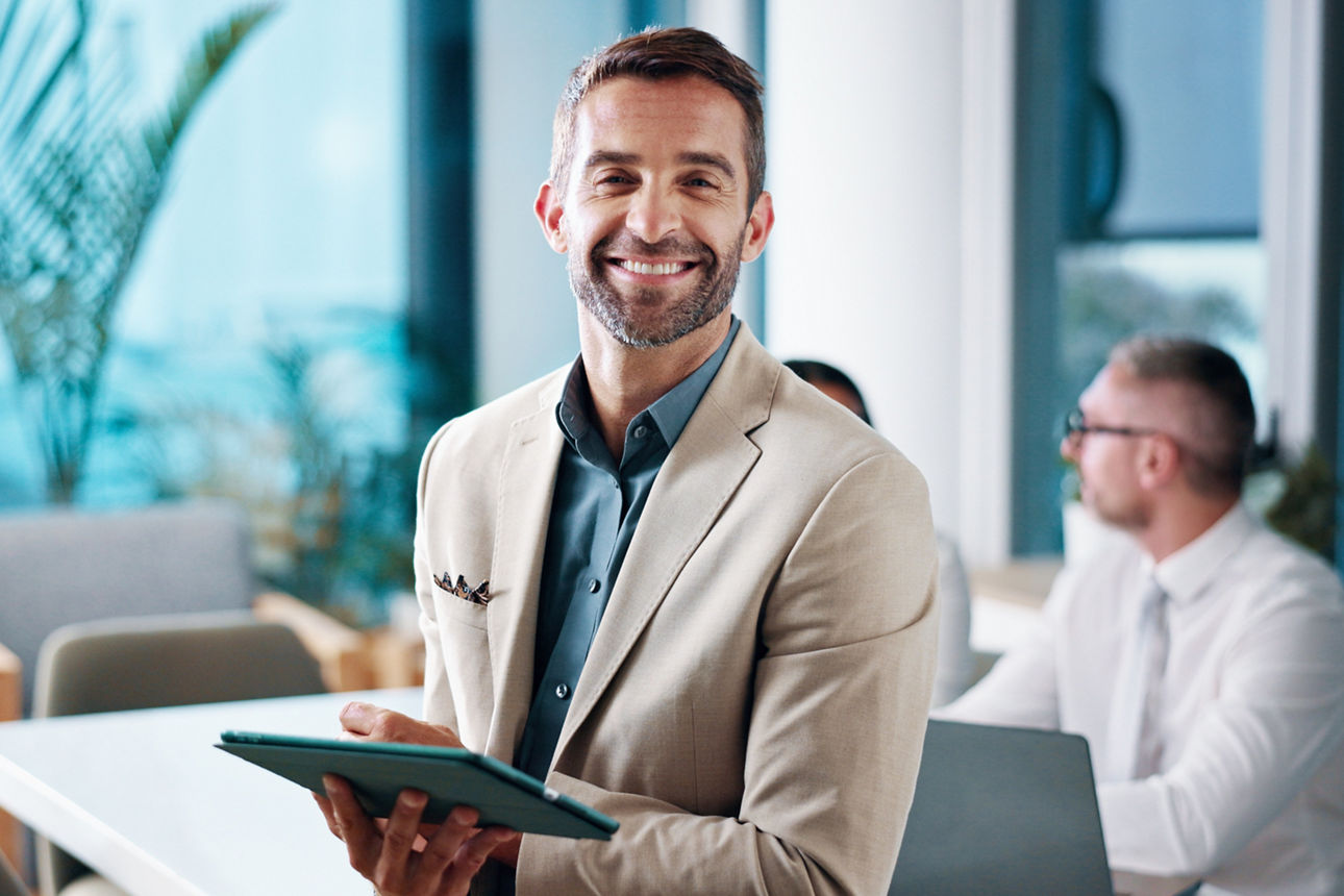 Ein Bankberater schaut lächelnd in die Kamera.