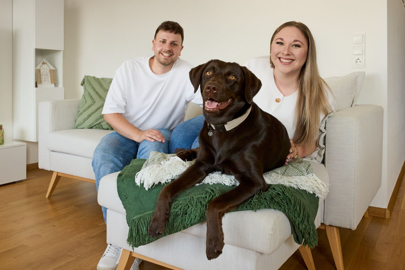 Junges Paar auf Couch mit Hund