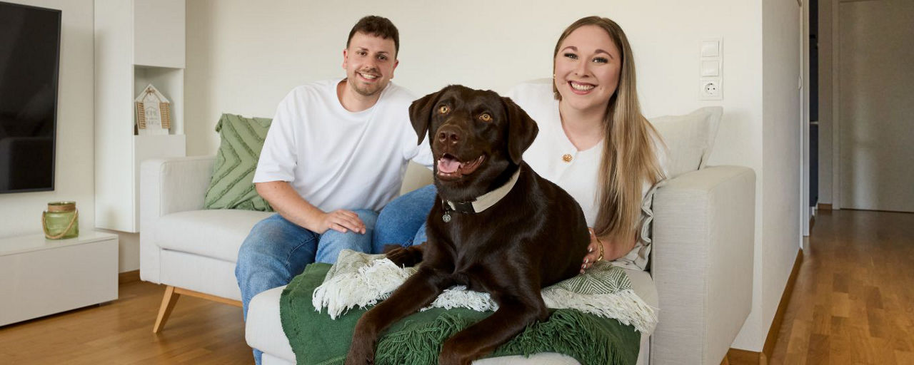 Pärchen mit Hund auf Couch
