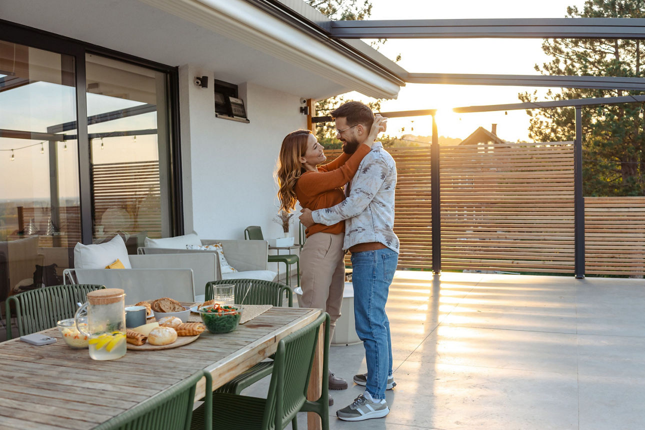 Junges Paar umarmt sich auf der Terrasse