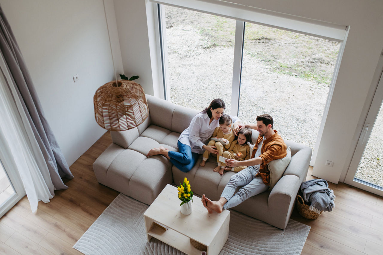 Familie mit zwei kleinen Kindern sitzt zusammen auf einer Couch