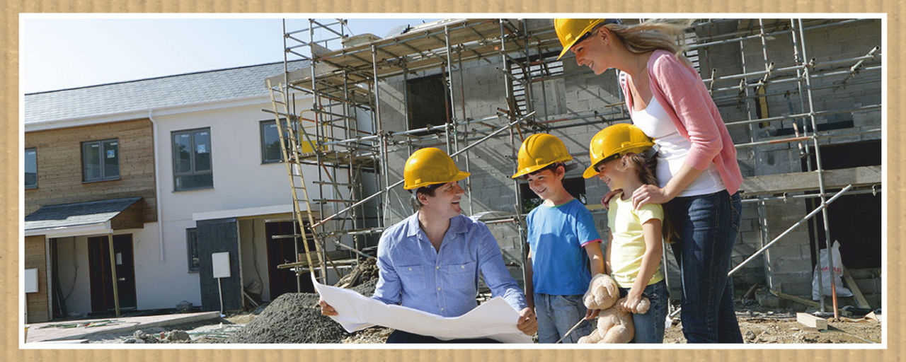 Famile mit Bauhelm auf der Baustelle