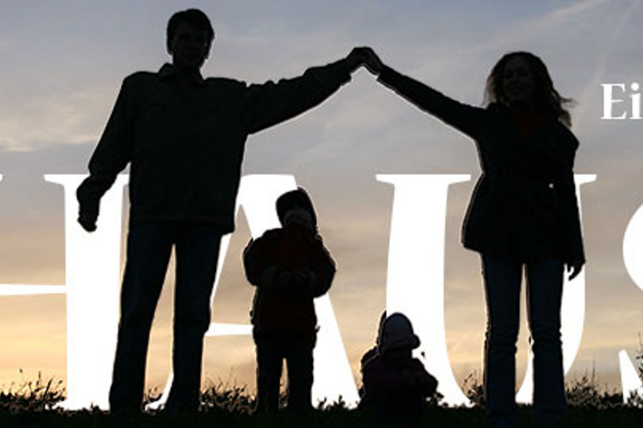 Eine vierköpfige Familie vor einem wolkenverhangenen Himmel