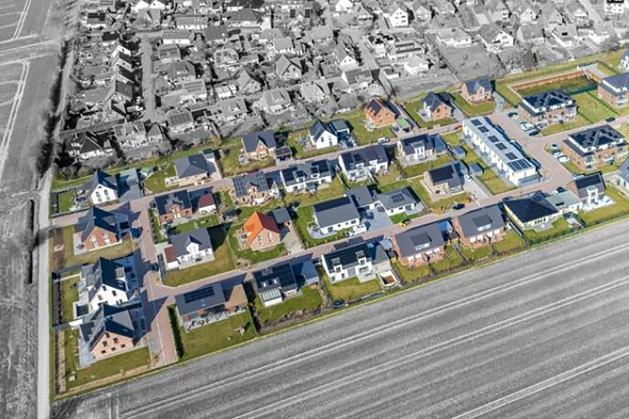 Ansicht eines weitläufigen Wohngebiets mit zahlreichen Häusern und Grünflächen. 