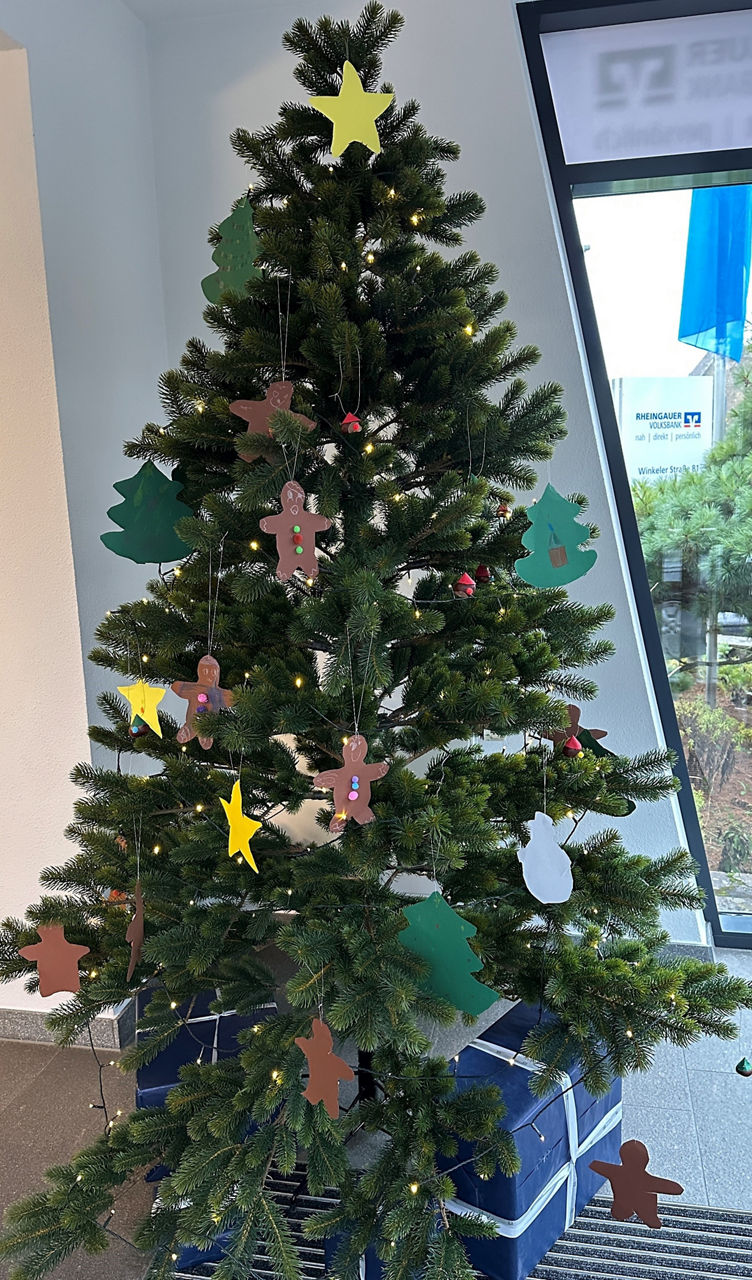 Weihnachtsbaum mit gelbem Stern an der Spitze, verziert mit Lebkuchenmännern, grünen Tannenbaumsilhouetten, gelben Sternen und bunten Anhängern.