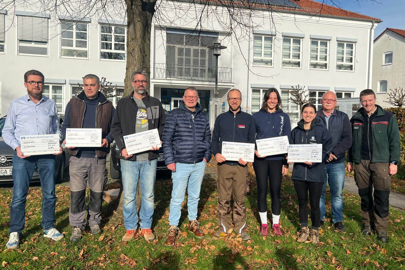 Gruppenbild von Menschen, die Spendenschecks in der Hand halten