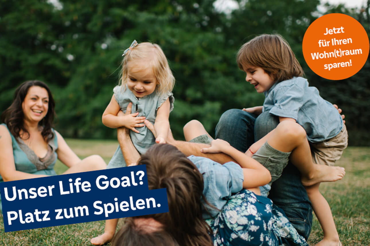 Eltern die mit ihren Kindern auf einer Wiese spielen