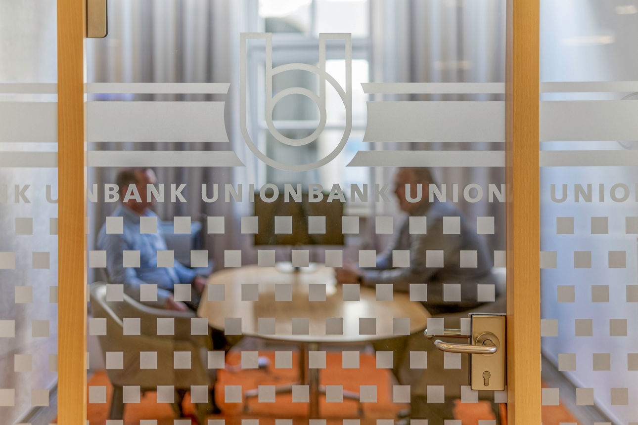 Beratungsgespräch hinter Glasfenster