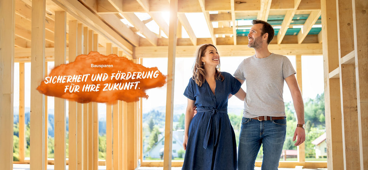 Junges Ehepaar steht glücklich im Rohbau eines Hauses. Links im Bild steht auf einem orangenen Feld "Bausparen Sicherheit und Förderung für Ihre Zukunft."