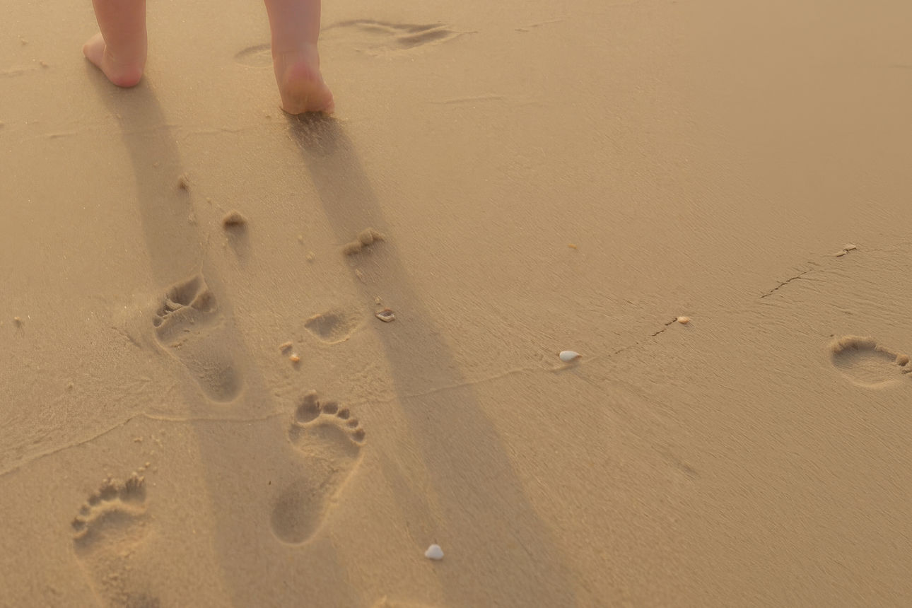 Kinderfüße und Spuren im Sand