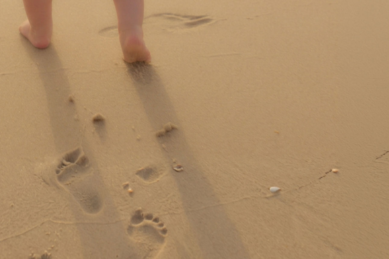 Kinderfüße und Spuren im Sand