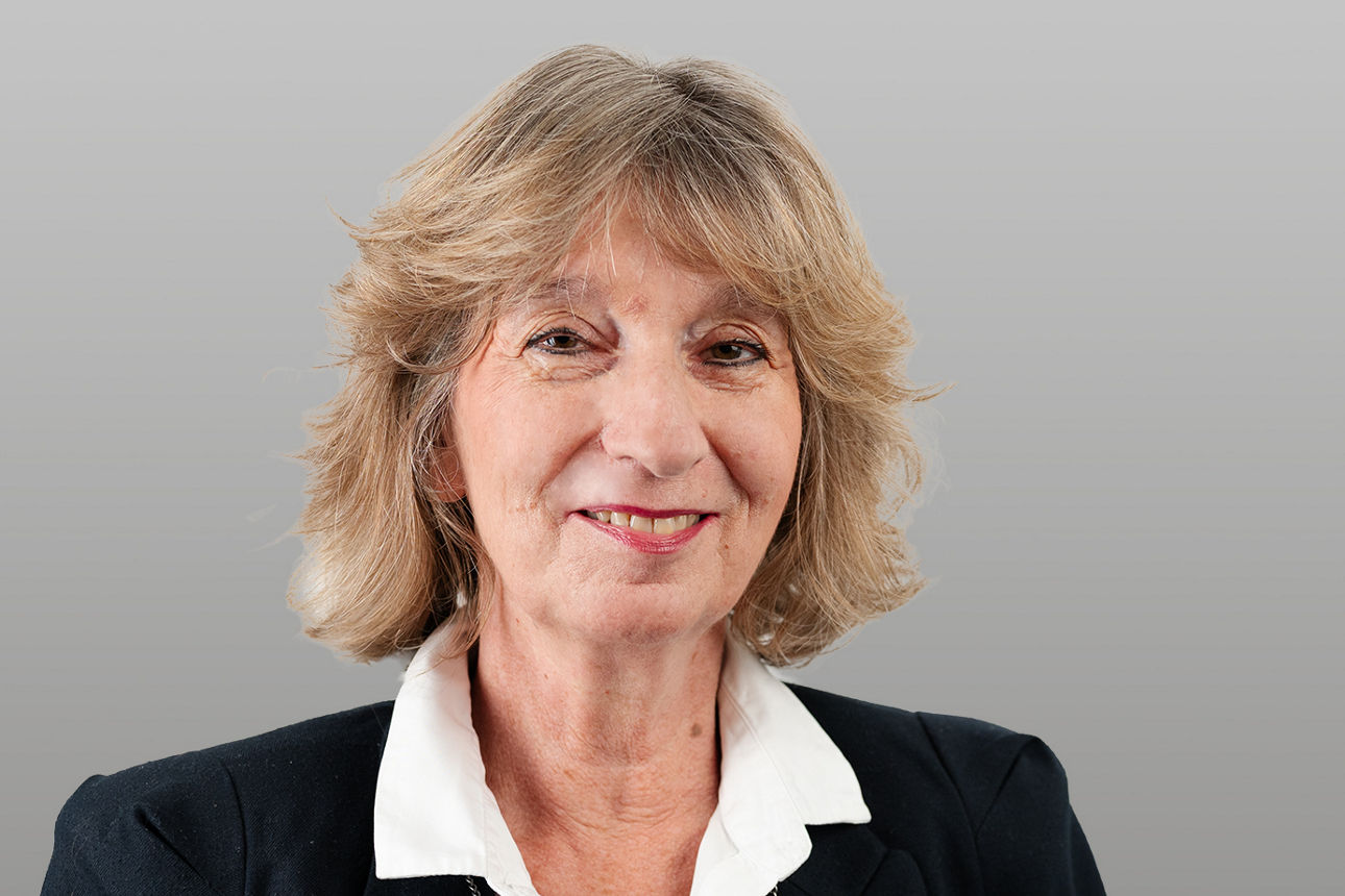 Bausparberaterin Ingeborg Behrend vor grauen Hintergrund