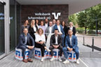 Gruppenfoto unserer Berater - 7 Frauen und 7 Männer vor dem Schriftzug Volksbank Schermbeck