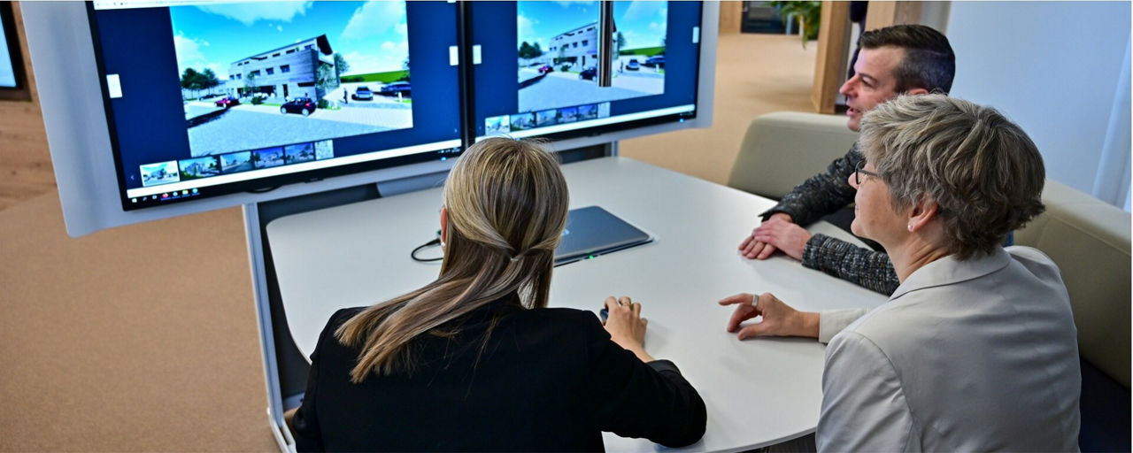 Immobilienmakler beraten Kunden am Beraterplatz