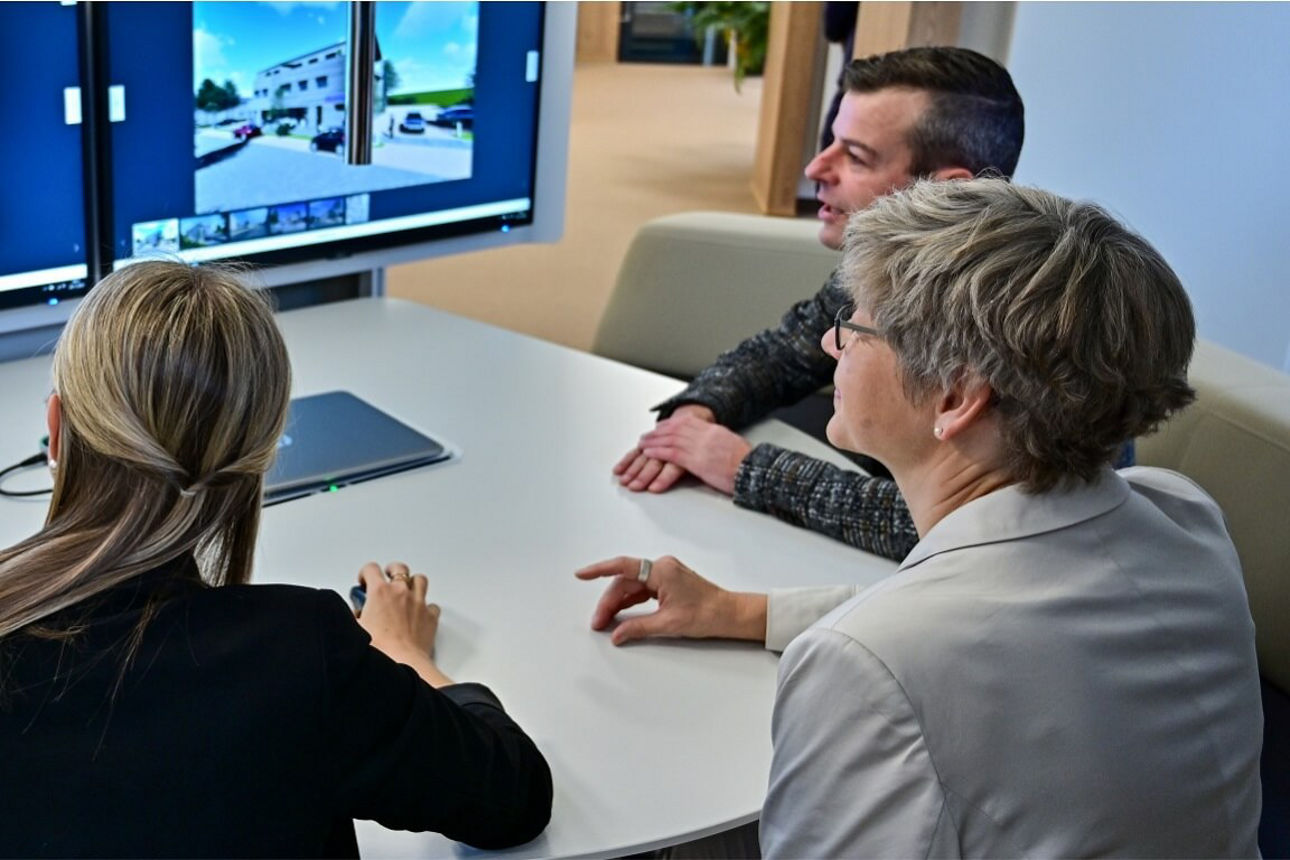 Immobilienmakler beraten Kunden am Beraterplatz