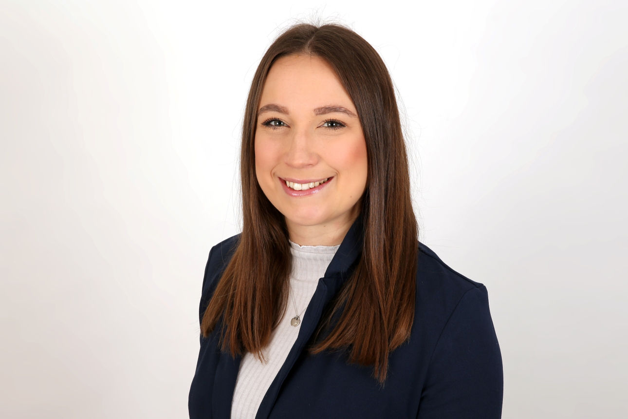 Eine lächelnder Frau schaut in die Kamera.