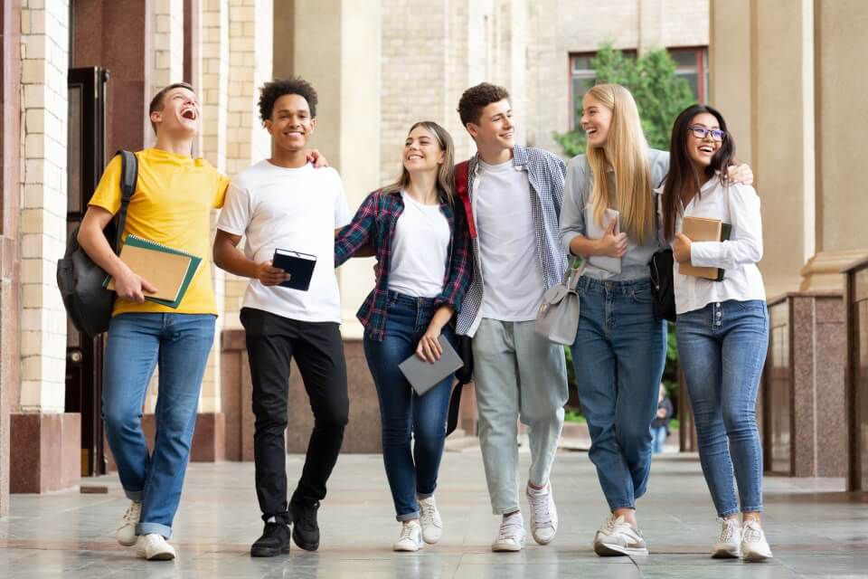 Gruppe junger Leute in einer Universität laufen in einer Reihe nebeneinander