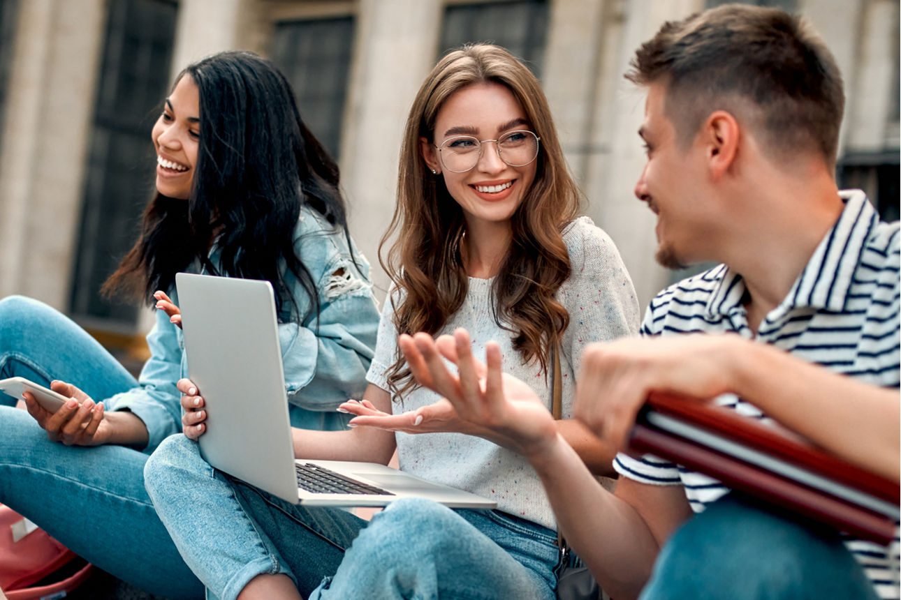 Eine Gruppe aus jungen Menschen unterhält sich auf einer Treppe