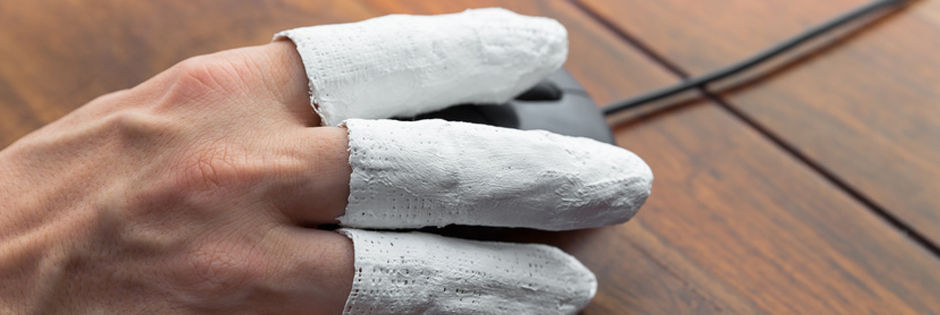 Finger in Gips an einer Computermaus